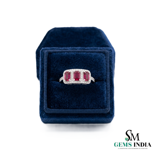 Ring with gemstones in a blue velvet box on a white background, branded 'SM Gems India'.