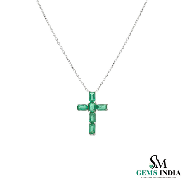 Gold necklace with a green gemstone cross pendant on a white background, branded 'SM Gems India'.