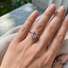 Hand wearing a ring with a pink gemstone on a neutral background, branded 'SM Gems India'.