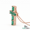 Cross pendant with emerald-cut green gemstones in rose gold setting with chain, elegant women’s jewelry design