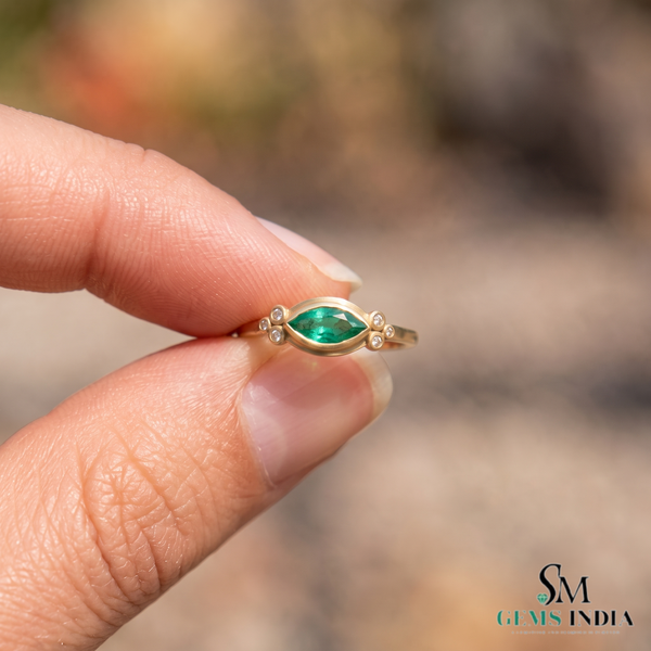 Ring mit Smaragd im Marquiseschliff und Diamanten in 14 Karat Gold. Eleganter Edelstein-Verlobungsring.