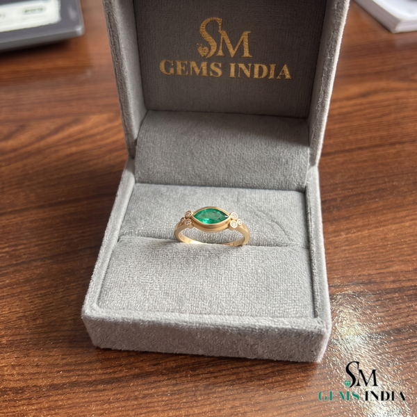 Ring mit Smaragd im Marquiseschliff und Diamanten in 14 Karat Gold. Eleganter Edelstein-Verlobungsring.
